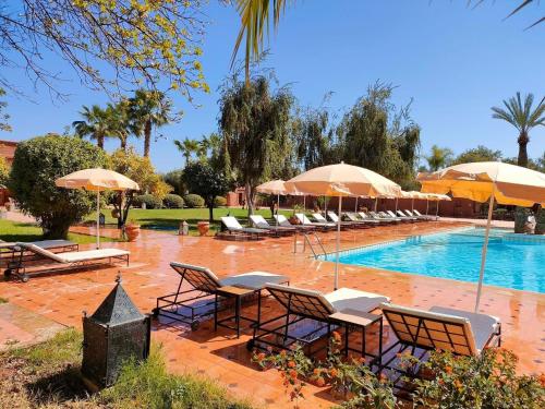 - une piscine avec des chaises longues et des parasols dans l'établissement LES JARDINS DE MARRAKECH, à Marrakech