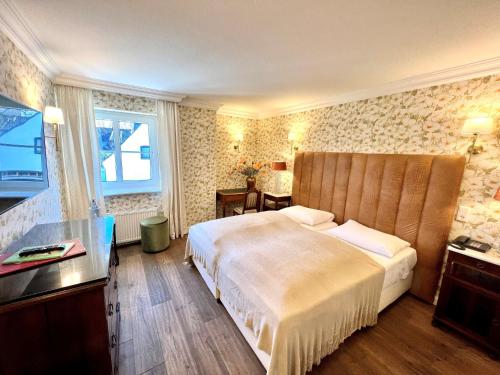 デュッセルドルフにあるホテル アシュリーズ ガーデンの大きなベッドと窓が備わるホテルルームです。