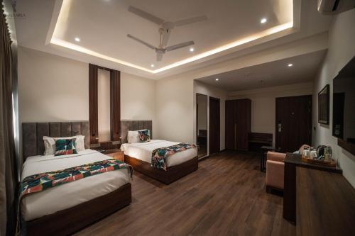 a hotel room with two beds and a desk at Aura Boutique Hotel in Udaipur