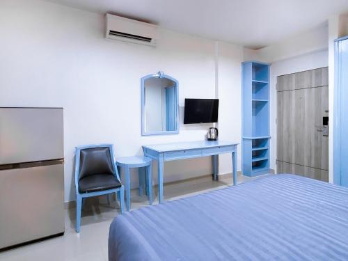 a bedroom with a bed and a desk with a computer at Chateau Hotel & Apartments in Pathum Thani
