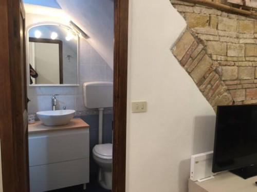 een badkamer met een wastafel, een toilet en een spiegel bij CARATTERISTICO APPARTAMENTO CENTRO SANREMO in Sanremo