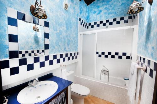a blue and white bathroom with a sink and a toilet at Posada El Pozu La Tejera in Pontejos