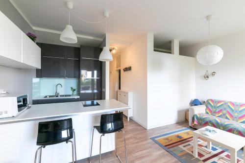 a kitchen and living room with a counter and chairs at Residence Vera Cruz in Lido di Jesolo