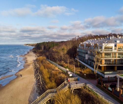 a building on the beach next to the ocean at Ustronie Apartments z widokiem na morze 20 m do plaży in Ustronie Morskie