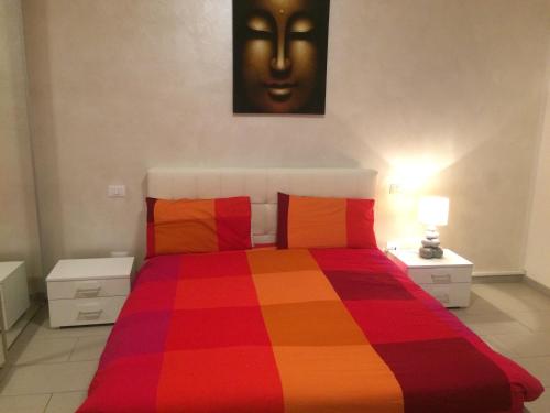 Un dormitorio con una colorida cama con una cara en la pared en Mechai Boatto Tumpat, en Marghera