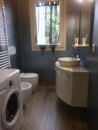 Un baño con lavadora y lavabo. en Mechai Boatto Tumpat, en Marghera