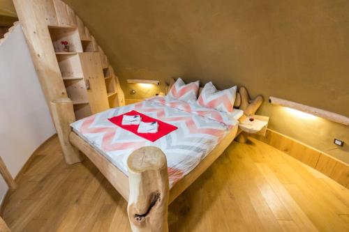 a bedroom with a wooden bed with a wooden floor at Magical Hobbit's House - Happy Rentals in Ljutomer