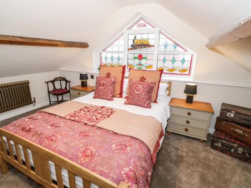 a bedroom with a bed and a stained glass window at Station Masters Cottage in Kidderminster