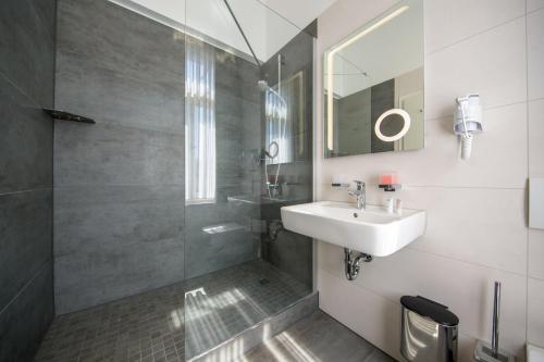 a bathroom with a sink and a shower at Sax Imperial in Dresden