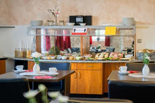 a restaurant with two tables and a counter with food at Sax Imperial in Dresden