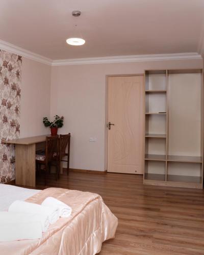 a bedroom with a bed and a desk and a table at Seva Guesthouse and Cottages Byurakan in Byurakan