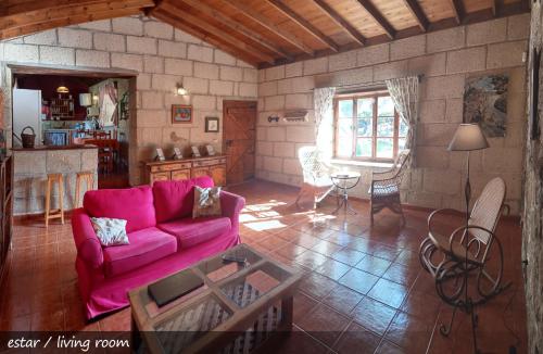 ein Wohnzimmer mit einem rosa Sofa und einem Tisch in der Unterkunft Live Finca San Miguel in San Miguel de Abona