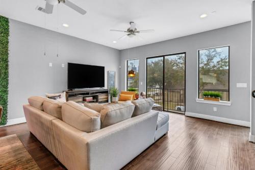 sala de estar con sofá y TV de pantalla plana en Modern, Houston Inspired House with Best Views of Downtown! - Less than 1 mile to Eado Midtown Bars home en Houston