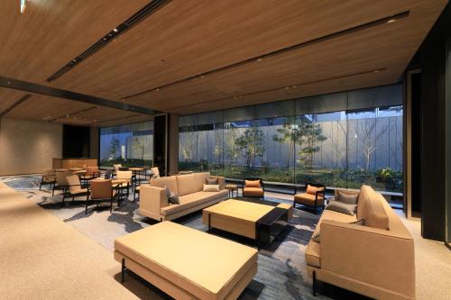 hol z kanapami, stołami i oknami w obiekcie Richmond Hotel Premier Kyoto Shijo w mieście Kioto