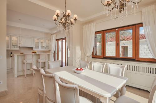 a kitchen and dining room with a white table and chairs at Villa Lovorno in Arbanasi