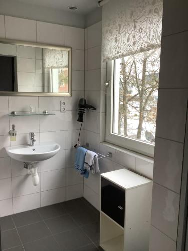 a white bathroom with a sink and a window at Budgethotel Stadtbett Wolfsburg in Wolfsburg