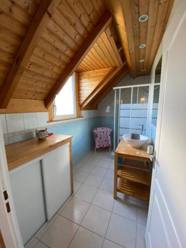 een badkamer met een wastafel en een houten plafond bij encodethhaure in Bartrés
