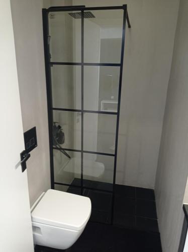 a bathroom with a toilet and a glass shower at NY Central 2 in Patra