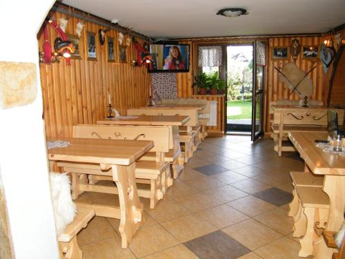 a dining room with wooden tables and benches at U Poraja in Ząb