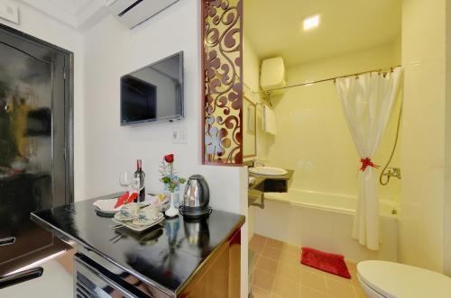 a bathroom with a sink and a toilet and a tub at Hai Yen Hotel in Hoi An