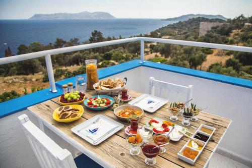 stół z jedzeniem i napojami na balkonie w obiekcie Selim Pansiyon w Kaş
