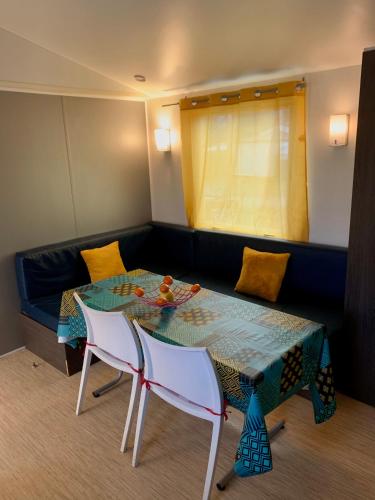une pièce avec une table, des chaises et un canapé dans l'établissement Mobil Home 6 personnes, à Saint-Chéron