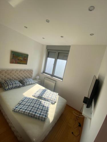 a bedroom with a bed with two pillows on it at Sofy Center Apartment (Free Parking) in Novi Sad