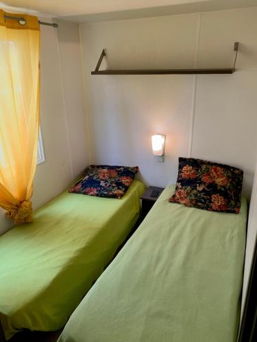 deux lits côte à côte dans une pièce dans l'établissement Mobil Home 6 personnes, à Saint-Chéron