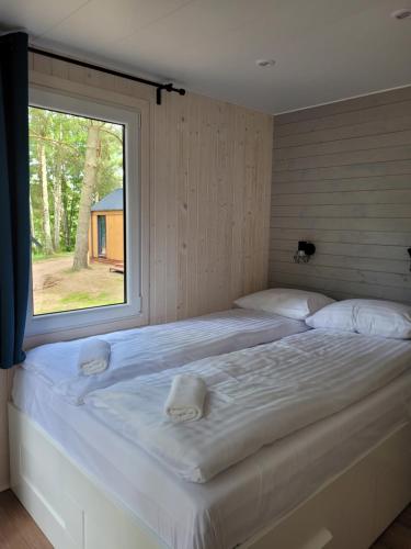 a large bed in a room with a window at Przystań Narie in Kretowiny