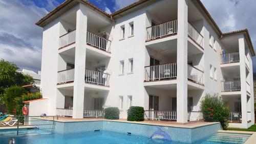 an apartment building with a swimming pool in front of it at Villa Allexia- APARTMENT SOL - Puerto Pollensa in Port de Pollensa