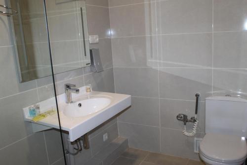 La salle de bains est pourvue d'un lavabo et de toilettes. dans l'établissement SK Hotel, à Bishkek