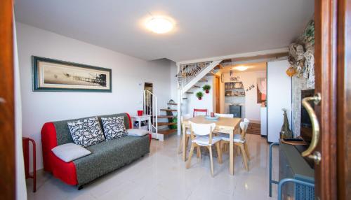 ein Wohnzimmer mit einem roten Sofa und einem Tisch in der Unterkunft Dimora Rubino in Pellestrina