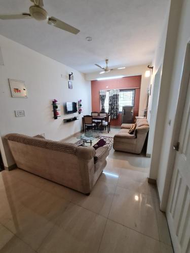 a living room with two couches and a table at S4 Sruthi Service Apartments in Chennai