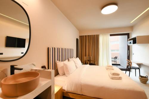 a hotel room with a bed and a bath tub at Pavo Art Hotel in Heraklio Town