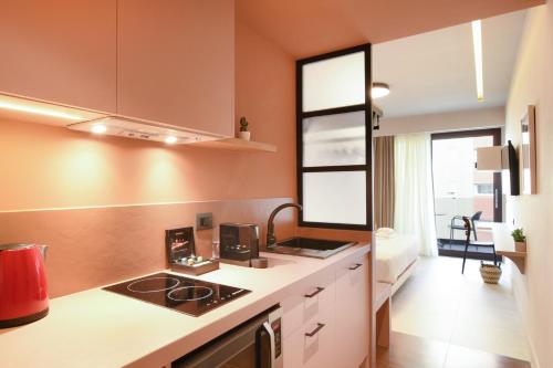 a kitchen with orange walls and a counter with a sink at Pavo Art Hotel in Heraklio Town