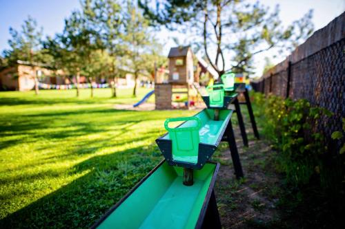 a row of green picnic tables in a park at Winiec Family Houses in Winiec