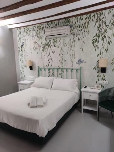 a bedroom with a large white bed and two tables at Hotel Almunia in Caravaca de la Cruz