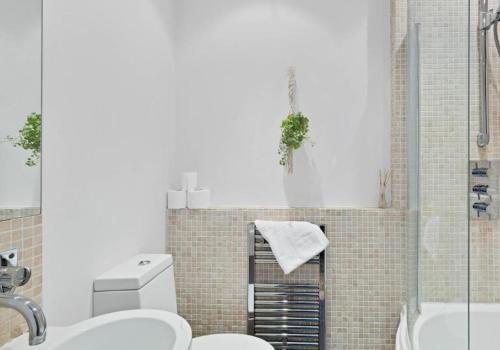a bathroom with a sink and a toilet and a shower at Boho Apartment In The Lanes in Brighton & Hove
