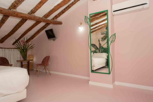 a bedroom with a bed and a mirror on the wall at Hotel Almunia in Caravaca de la Cruz