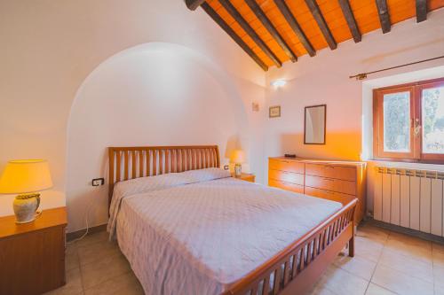 a bedroom with a bed and a dresser and a window at Casa Alex a Schiopparello - Goelba in Portoferraio