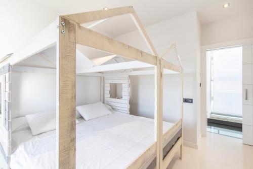 a bedroom with a bunk bed with white sheets at Casa vista alegre in Atarfe