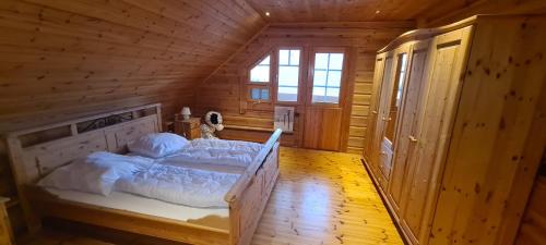 a bedroom with a bed in a wooden cabin at Berglodge für 10 Personen mit Sauna in Sehmatal