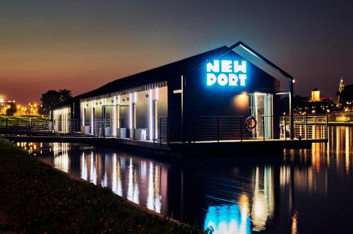 a building with a new dont sign on it at night at New Port Aparthotel in Kraków