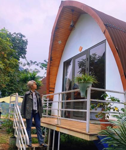 a man standing in front of a tiny house at Areca Bungalow in Phong Nha