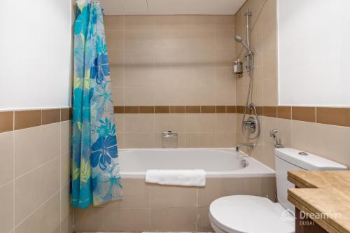 a bathroom with a tub and a toilet at Dream Inn Apartments - 29 Boulevard Private Terrace in Dubai