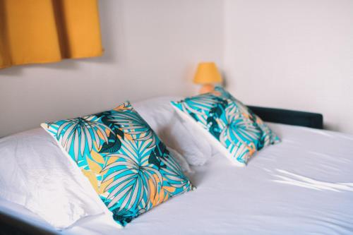2 poduszki na łóżku w pokoju w obiekcie Bungalow de Nola w mieście Le Lamentin