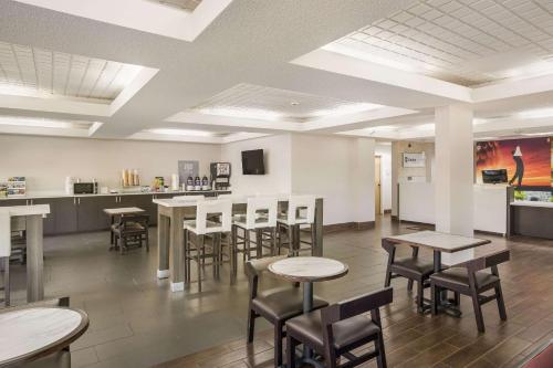 a dining room with tables and chairs and a counter at Clarion Pointe Forsyth I-75 in Forsyth