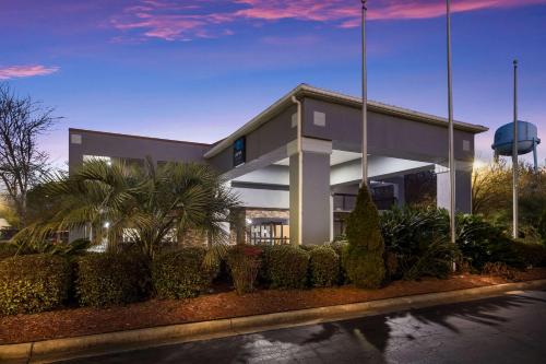 a building with trees and bushes in front of it at Clarion Pointe Forsyth I-75 in Forsyth