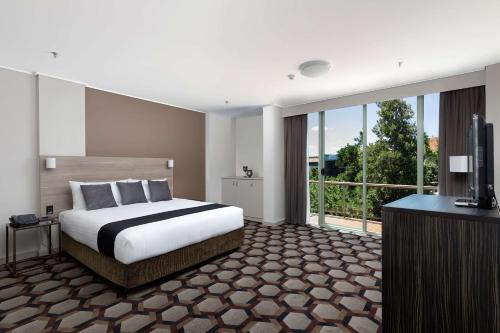 a hotel room with a bed and a television at Rydges Canberra in Canberra