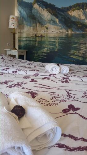 a bedroom with a bed with towels on it at Klintholm B & B Bistro in Borre